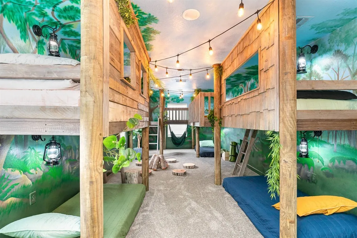 Jungle treehouse themed bedroom with multi-level bunk beds and tropical murals