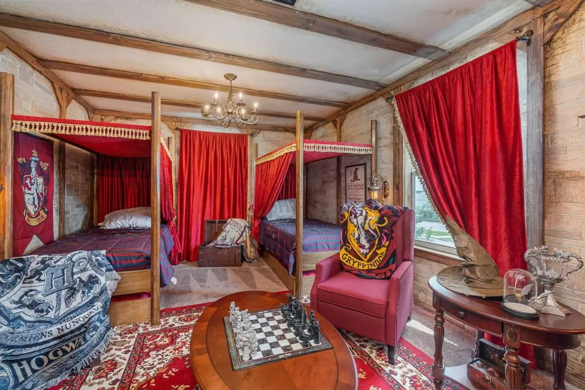 Harry Potter Gryffindor themed bedroom with stone walls and red canopy beds