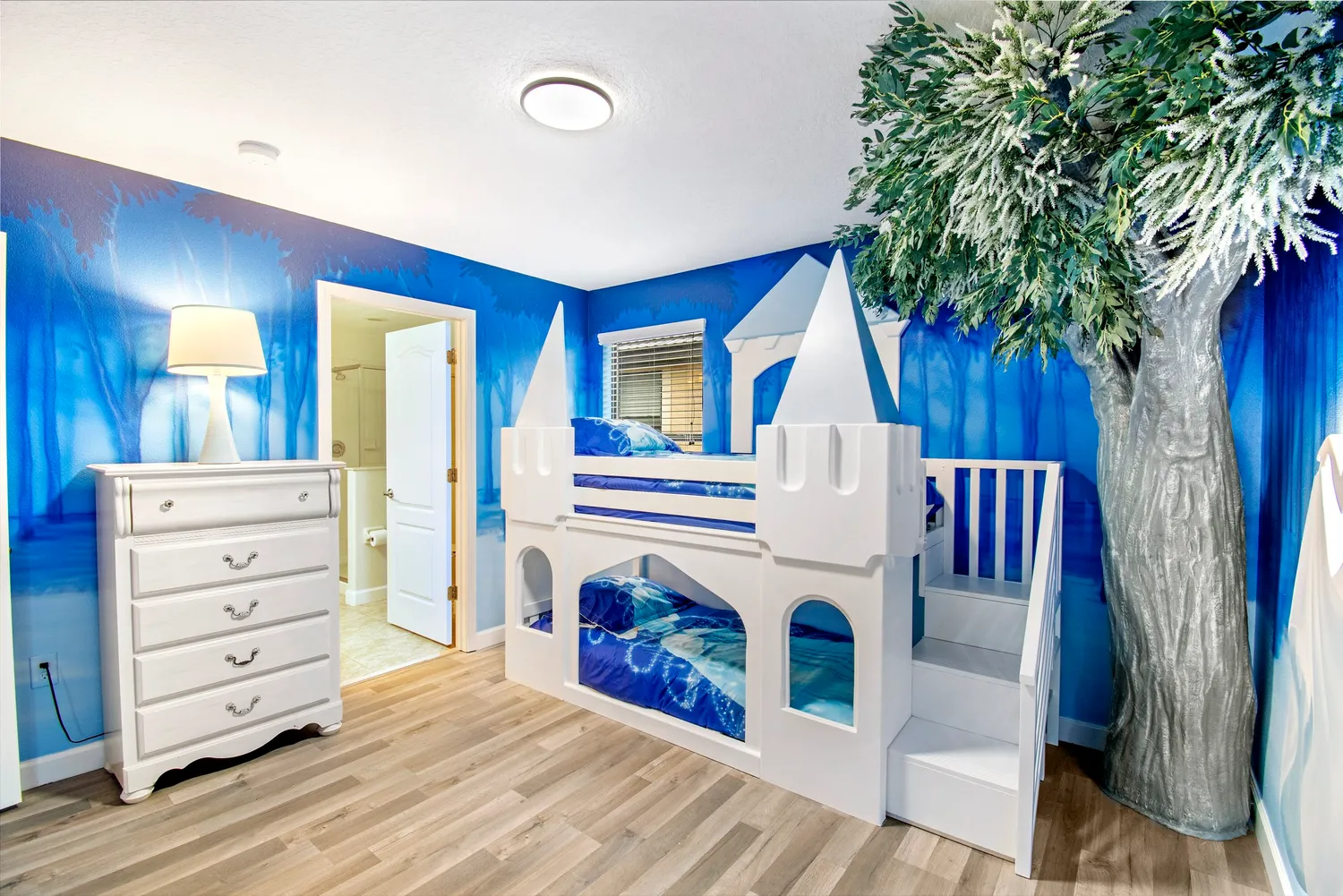 Frozen ice castle themed bedroom with white castle bunk bed and blue walls