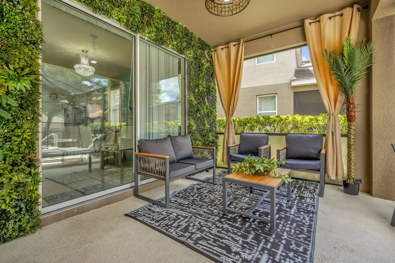 Luxury outdoor patio lounge with living green wall, hanging curtains, and modern seating