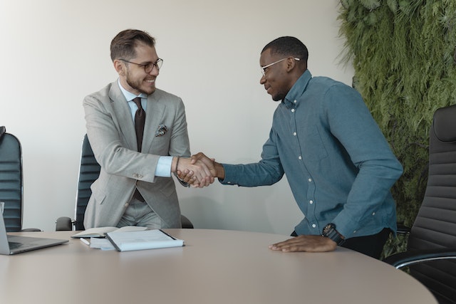 two-business-professionals-shaking-hands-over-a-table